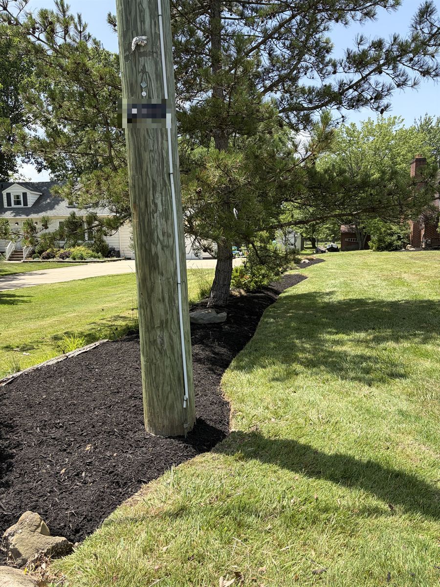 After: a clean new mulch bed with a sharp edge along the road