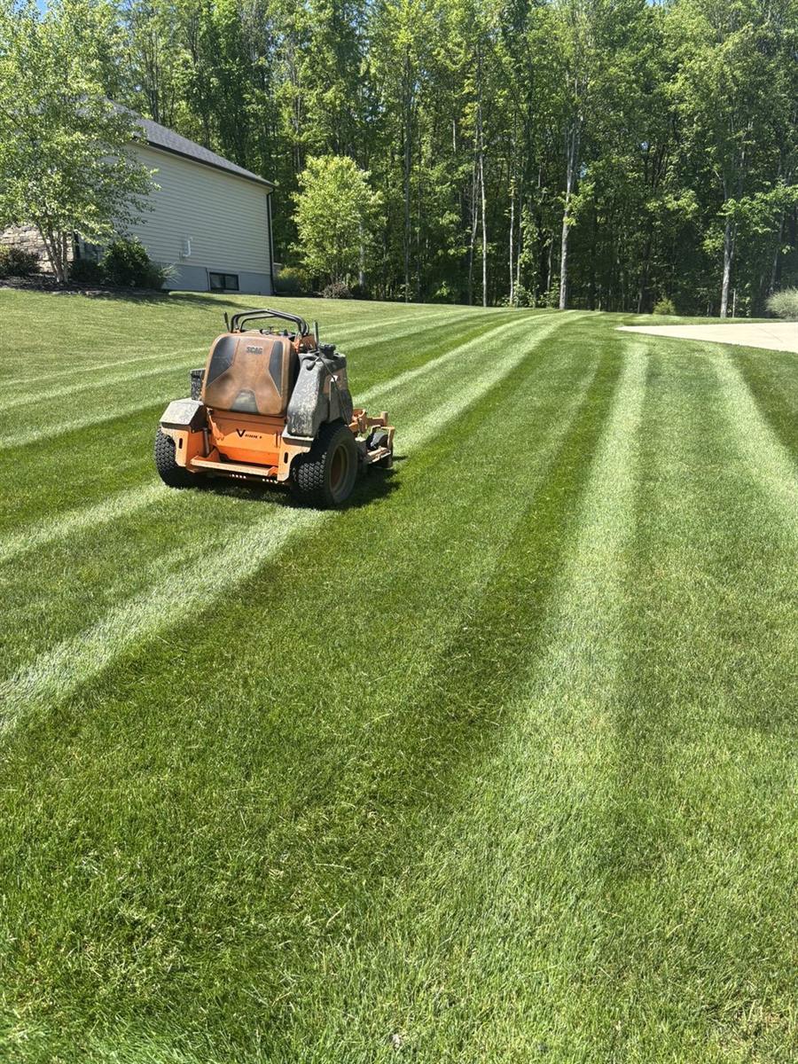 Stand-on mower cutting stripes into a lawn